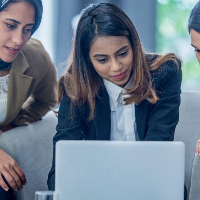 Three women in financial technology sector collaborating over computer screen